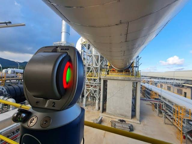Laser tracker set up outdoors measuring a large industrial structure